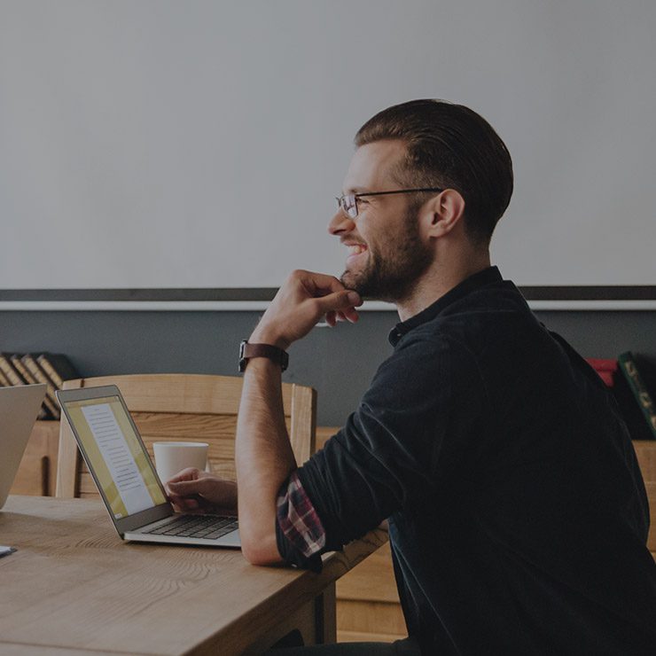 a man sitting in front of computer with her smile